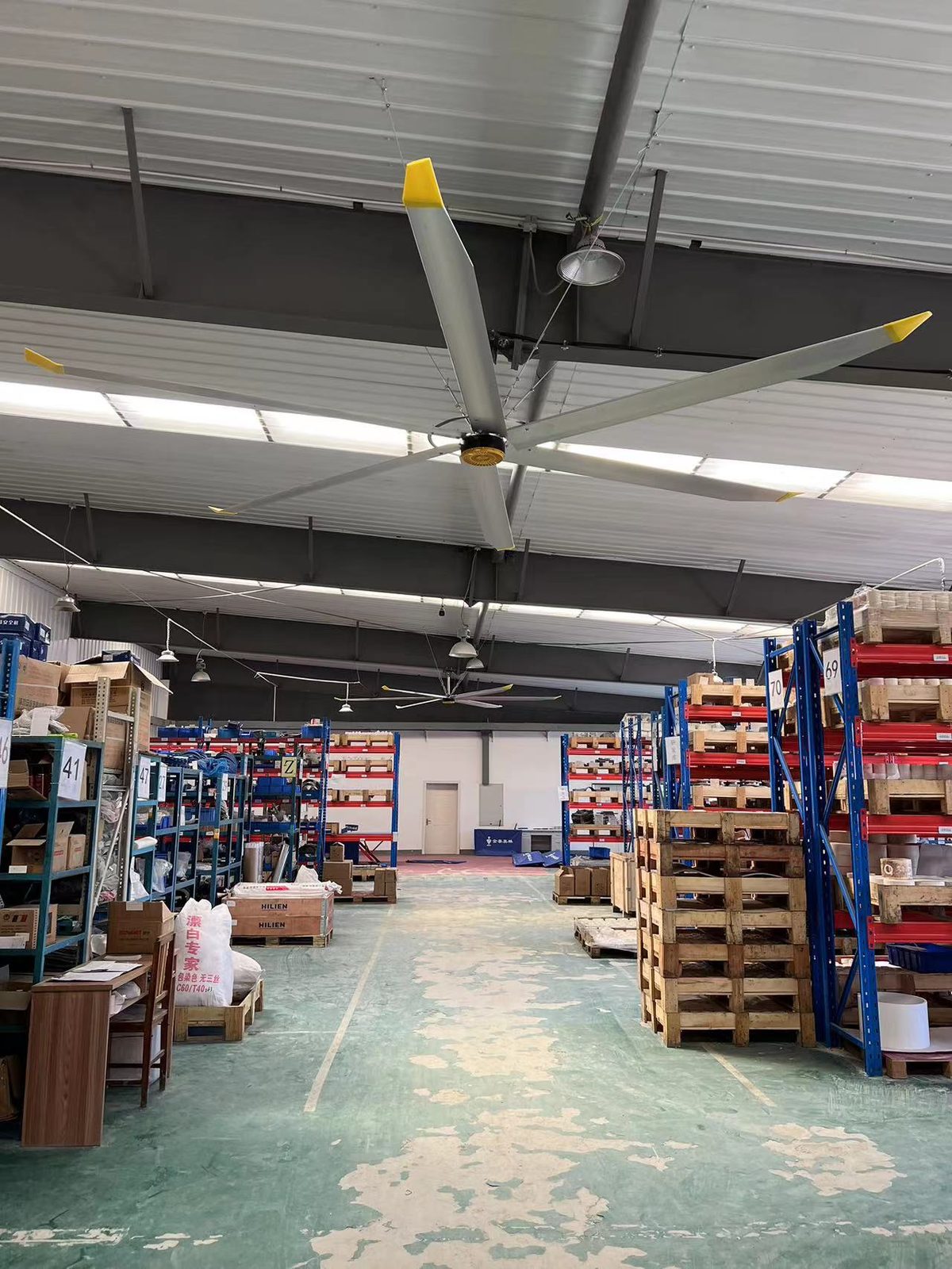 Large HVLS fan circulating air through a tall industrial interior